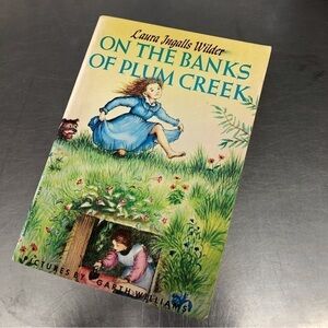 On the Banks of Plum Creek by: Laura Ingalls Wilder, paperback book